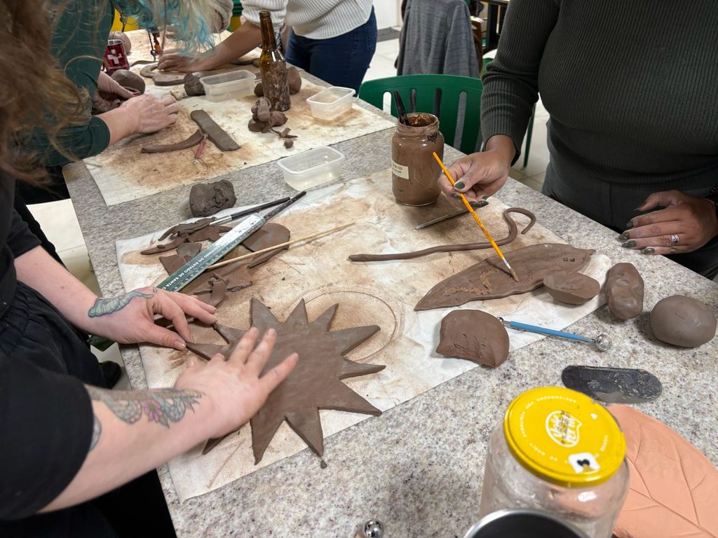 Na imagem, duas mulheres criando artesanato a partir de materiais orgânicos, com a argila.